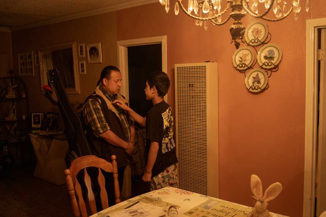 Paulo “El Maniacs” Paredones, the bass player for Spaghetti Cumbia is blessed by his son, Tekuanotl Huitzitzilin, before he leaves for a show in Boyle Heights on March 30, 2023. He is the primary care giver to his son. The band Spaghetti Cumbia created their own sub-genre by combining cumbia with western styles and rock ’n roll. They grew up on the east side of Los Angeles when gang violence plagued the area; the members turned to music as an alternative path. Now, they rock clubs, while keeping day jobs to support their families.