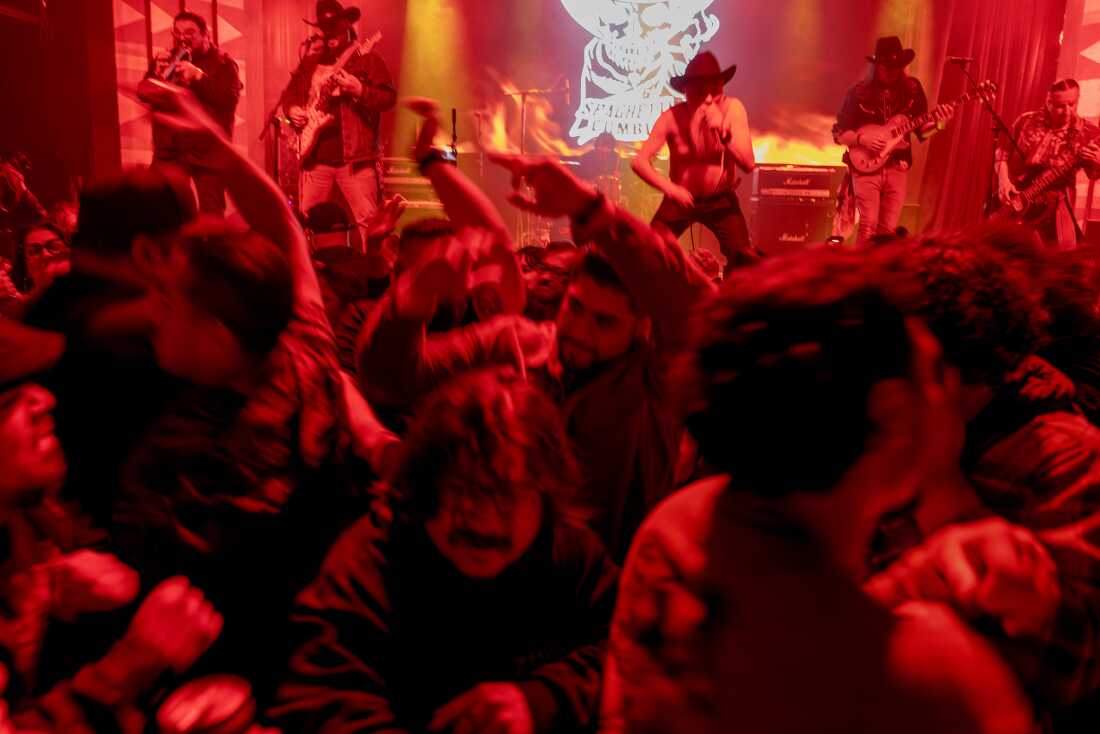 A mosh pit forms at the Regent Theater as Spaghetti Cumbia plays in Los Angeles on March 8, 2025. Spaghetti was followed by Vilma Diaz, a Colombian Cumbia star. he band Spaghetti Cumbia created their own sub-genre by combining cumbia with western styles and rock ’n roll. They grew up on the east side of Los Angeles when gang violence plagued the area; the members turned to music as an alternative path. Now, they rock downtown Los Angeles clubs, while keeping day jobs to support their families.