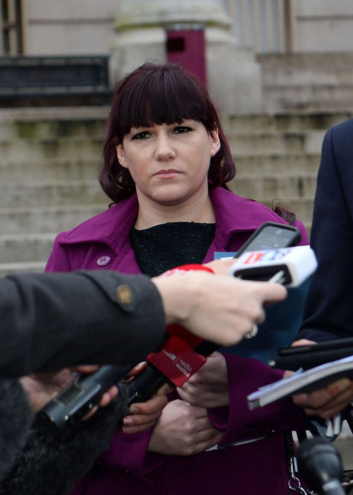 Una mujer con un abrigo morado habla con los periodistas frente al tribunal sobre la estrella de rock que fue atacada fatalmente en un caso de prisión.