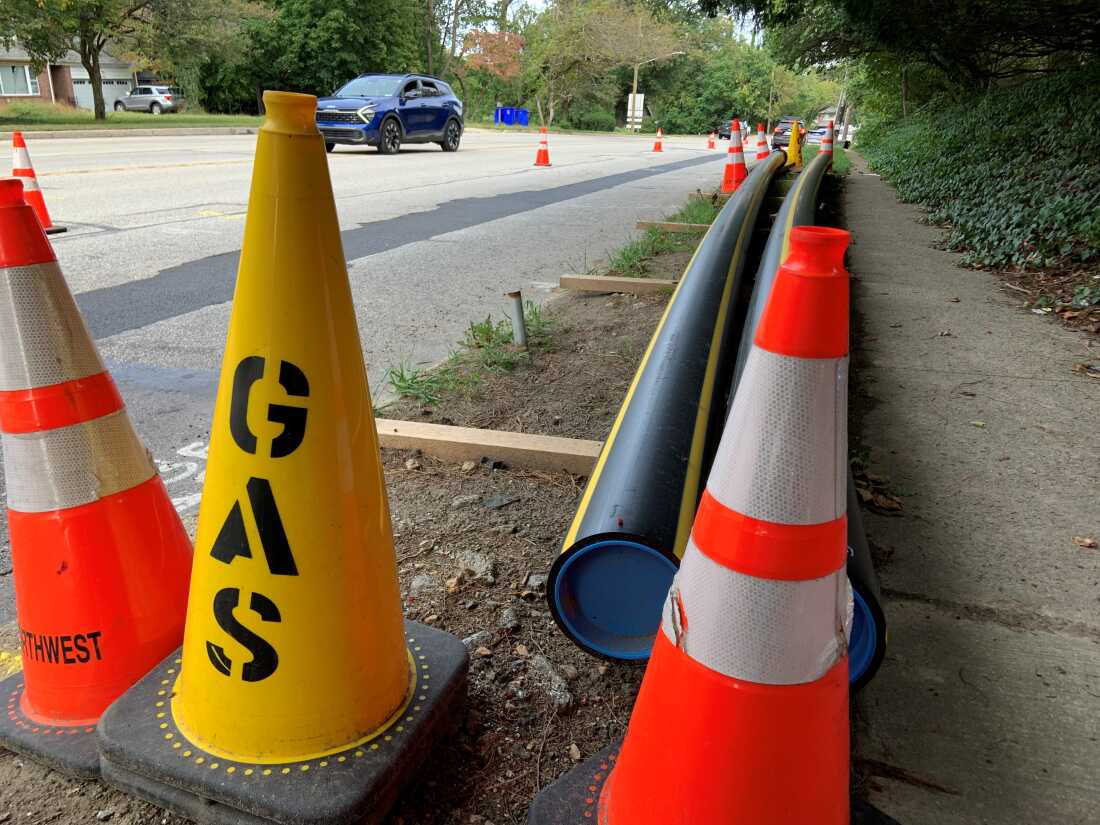 En Wyncote, Pensilvania, largas tuberías de gas con conos de tráfico alrededor descansan a lo largo de una calle.
