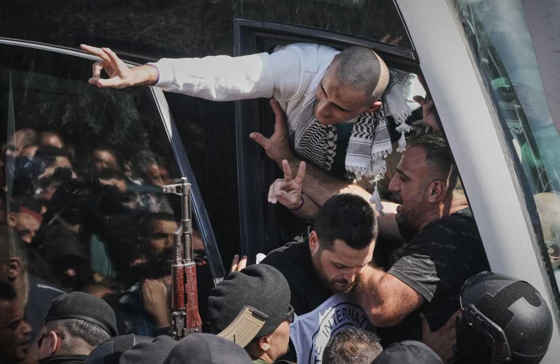 Los prisioneros palestinos saludan a la multitud después de ser liberados de una prisión israelí tras un acuerdo de alto el fuego entre Israel y Hamas, en la ciudad cisjordana de Ramallah el lunes.