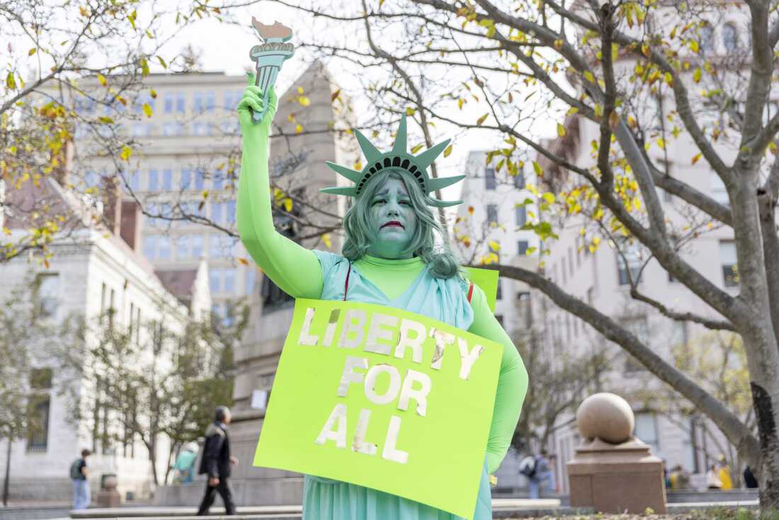 Tara Reel, vestida como la “doliente” Estatua de la Libertad, una reciente trabajadora federal que aceptó el programa de renuncia diferida. Grandes multitudes se reunieron en el centro de Washington DC el 18 de octubre de 2025 para la manifestación “No Kings”.