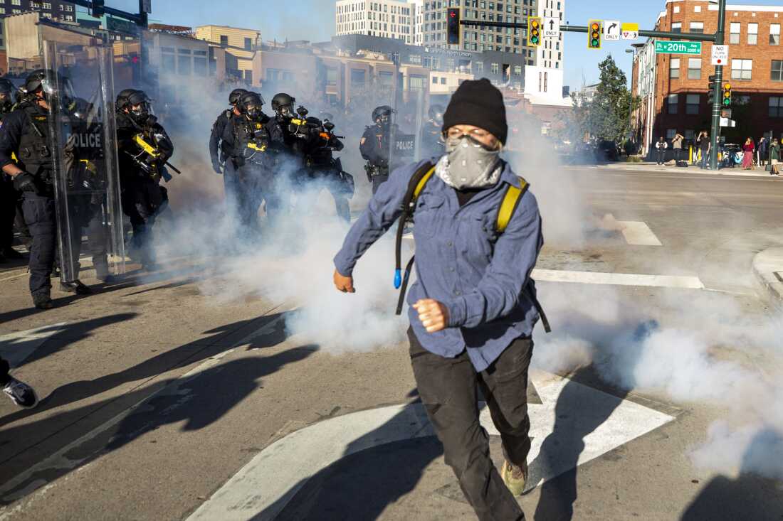 Los agentes de policía disparan bolas de pimienta y arrojan botes de productos químicos a un pequeño grupo de manifestantes que se negaron a dispersarse de las calles 20 y Wewatta en Denver después de que terminara la manifestación principal de No Kings el 18 de octubre de 2025.