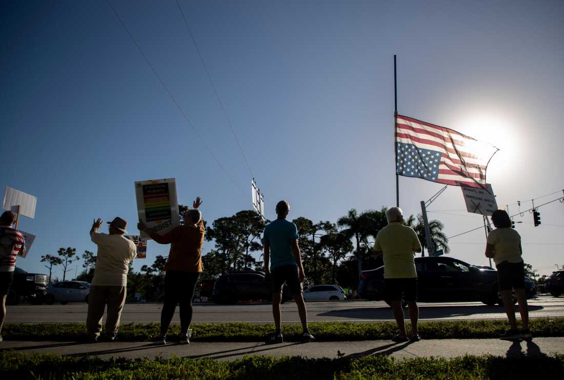 Los manifestantes que se alinean en la esquina de Daniels Parkway y la US 41 sostienen carteles en la manifestación No Kings en Fort Myers el sábado 18 de octubre de 2025.