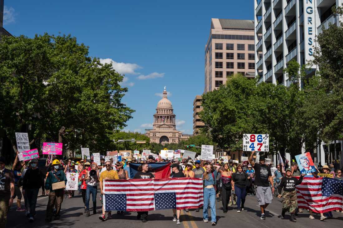Una mujer canta mientras marcha por Congress Avenue durante la 