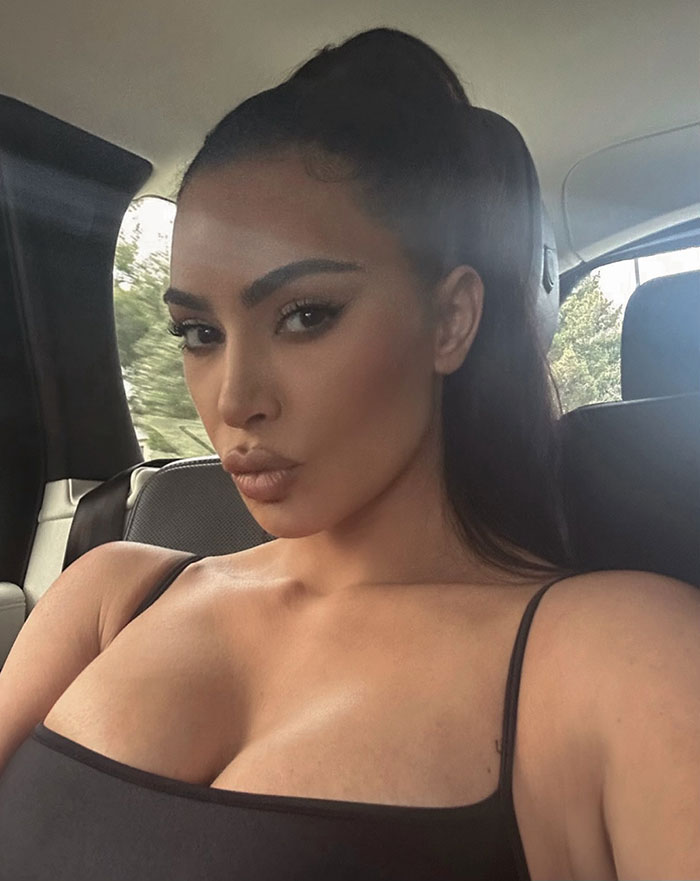 Mujer con cabello oscuro recogido en una coleta alta y con una camiseta negra sin mangas, destacando la advertencia de Kanye West sobre los riesgos de la vida en línea.