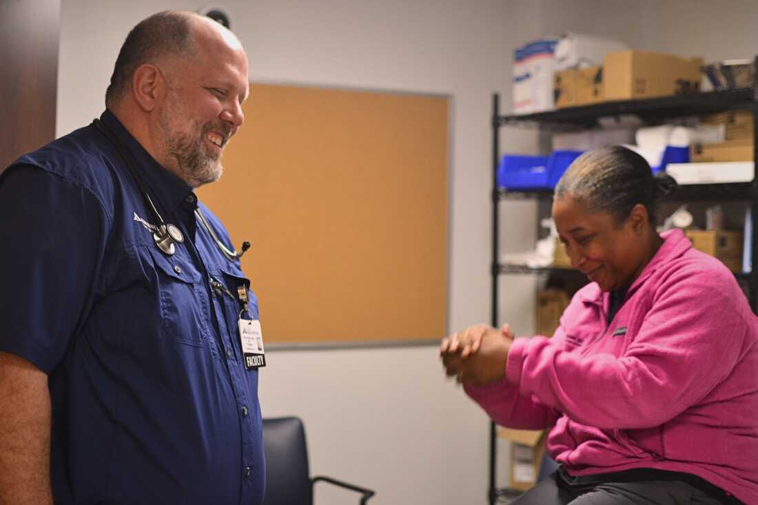 El Dr. Brent Smith, izquierda, médico de una clínica de atención primaria en Delta Health System en Greenville, Mississippi, se ríe con un compañero de trabajo.