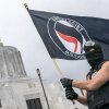 Un manifestante ondea una bandera antifascista en la sede estatal de Oregón el 28 de marzo de 2021. El presidente Trump dice que designará a Antifa “como una importante organización terrorista”.