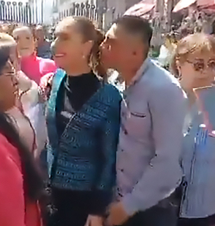 Un hombre besa y acaricia a la presidenta mexicana mientras ella habla ante la multitud, resaltando la realidad para muchas mujeres en espacios públicos.