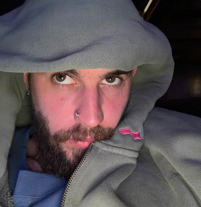 Justin Bieber con una chaqueta con capucha, primer plano de su rostro con fanáticos expresando preocupación después de notar algo inusual.