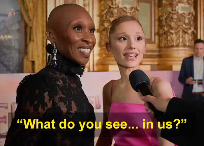 Cynthia Erivo y Ariana Grande en un evento, participando en una nueva interacción extraña durante una entrevista.