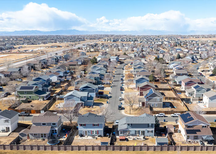 Vista aérea de un barrio suburbano con casas y garajes, relacionada con el cuerpo de una mujer desaparecida descubierto en el garaje.