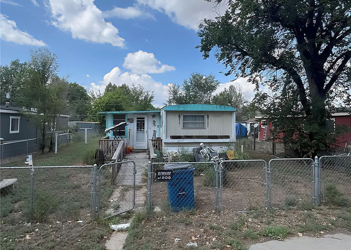 Pequeña casa con patio cercado y 