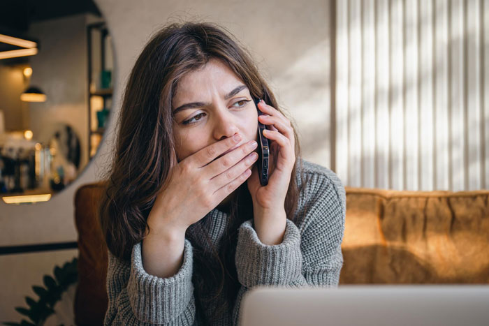 Una joven que cuida a los hijos de su hermana parece preocupada mientras habla por teléfono durante un partido de hockey en casa.