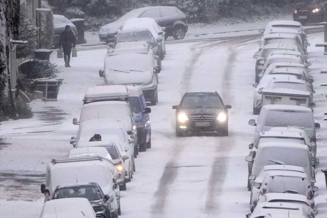 Un automóvil conduce con cuidado por una calle nevada cuando la gente se enfrenta a una ola de frío que trae el clima invernal con nieve y hielo a la zona industrial del Ruhr en Gelsenkirchen, Alemania, el miércoles 7 de enero de 2026. 
