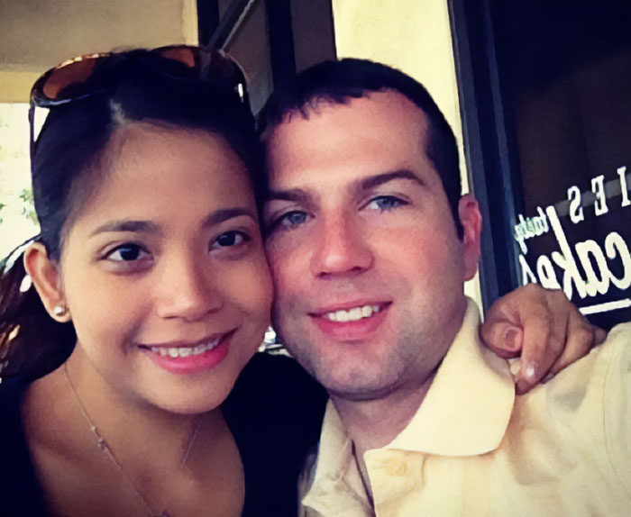 Pareja sonriendo muy juntos en un ambiente informal, relacionados con el padre de un agente de ICE en medio de noticias sobre su esposa inmigrante.