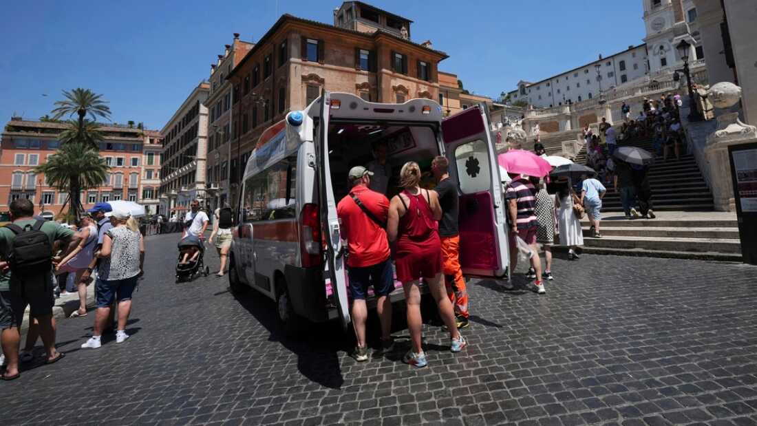Los paramédicos brindan ayuda el 1 de julio a turistas y residentes con una ambulancia junto a la histórica Plaza de España en Roma, Italia.