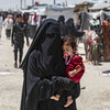 Una mujer carga a un niño mientras camina por el campo de refugiados de al-Hol, en el noreste de Siria, en octubre de 2023.
