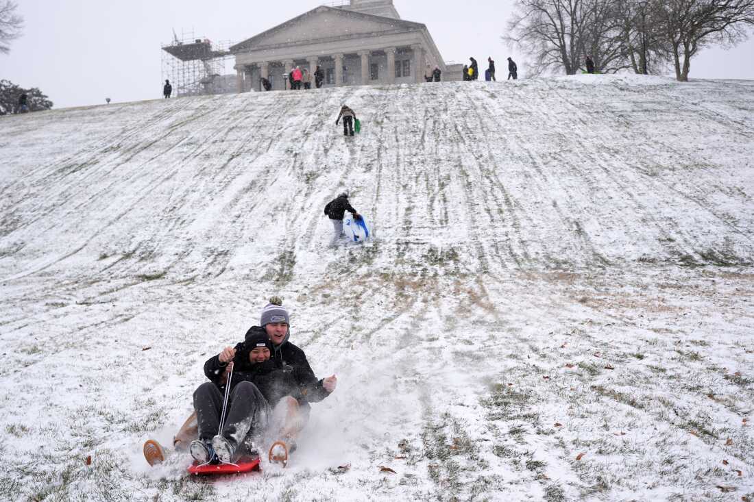Yana Beeker, al frente, Roddy Peterson, detrás, se deslizan cuesta abajo en el Capitolio estatal durante una tormenta invernal el sábado 24 de enero de 2026 en Nashville, Tennessee.