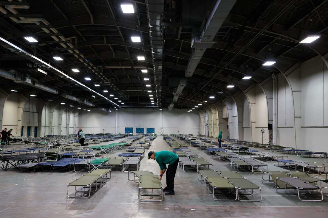Los voluntarios preparan catres en un refugio para las inclemencias del tiempo antes de una tormenta invernal en Fair Parks Automobile Building en Dallas, Texas, el 23 de enero de 2026. 