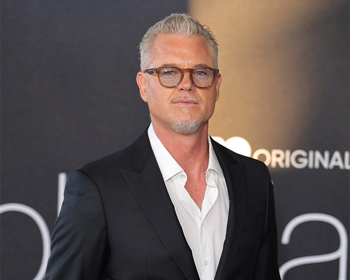 Eric Dane con gafas y traje negro, asistiendo a un evento relacionado con sus desgarradoras últimas palabras para sus hijas.