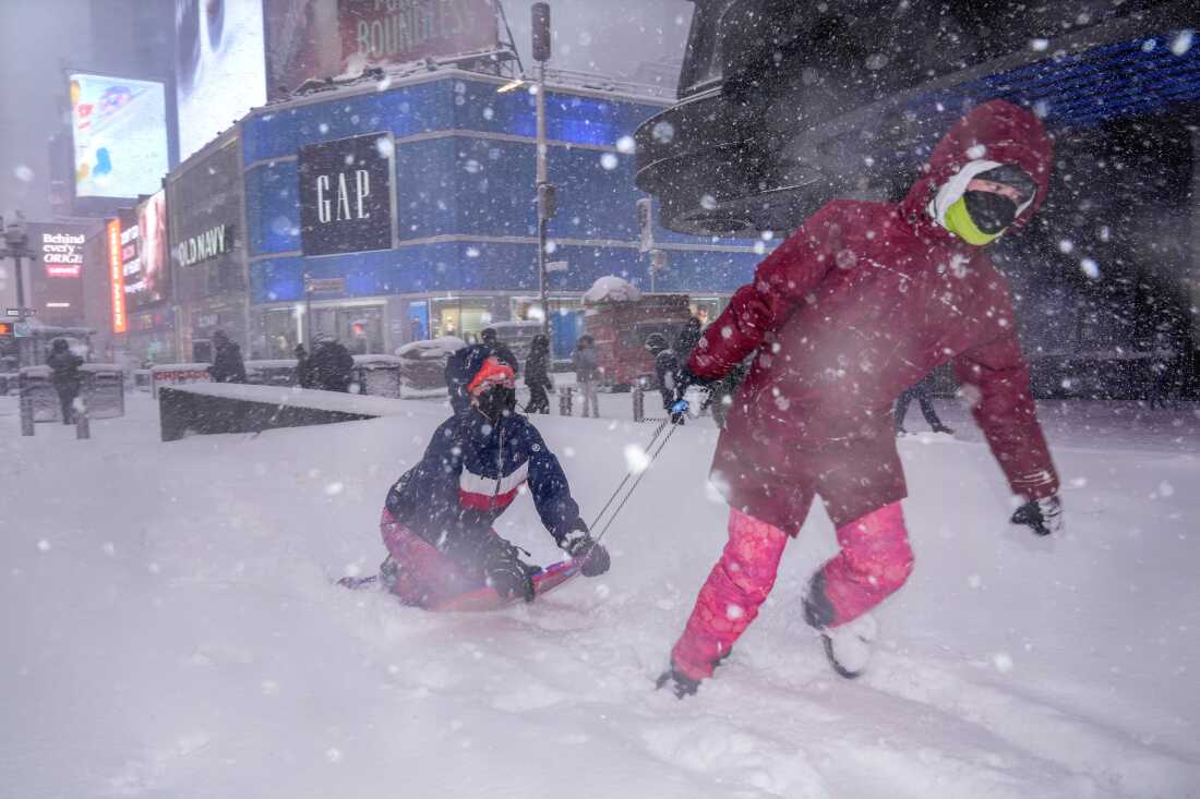 Hannah y Astrid Grimskog juegan en Times Square durante una tormenta de nieve, el lunes 23 de febrero de 2026, en Nueva York.