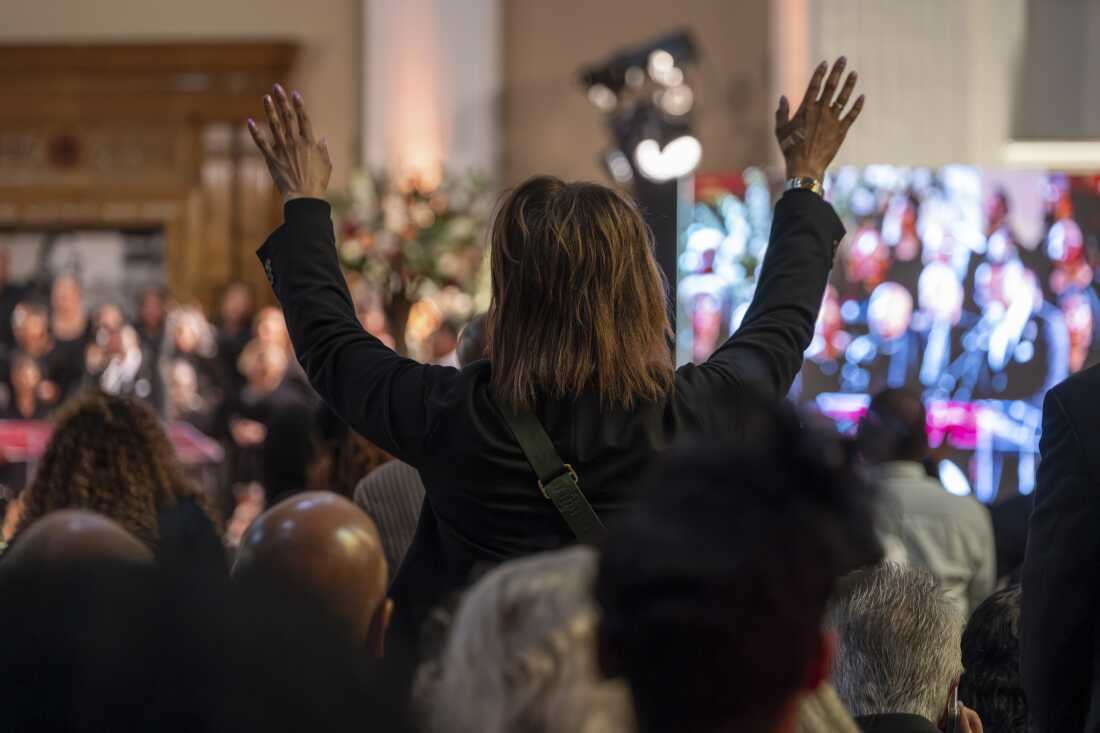 Un partidario levanta la mano durante el funeral del reverendo Jesse Jackson en la sede de la Coalición Rainbow PUSH. (Kenn Cook Jr. para NPR)