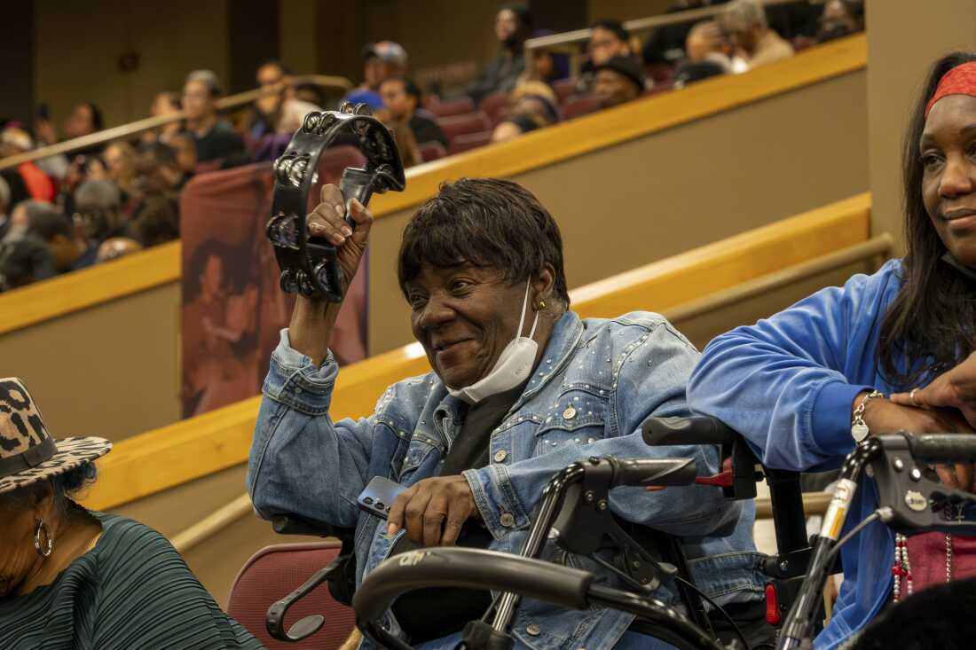 Un asistente levanta una pandereta durante un tributo musical en un servicio público de regreso al hogar del reverendo Jesse Jackson en House of Hope el viernes.