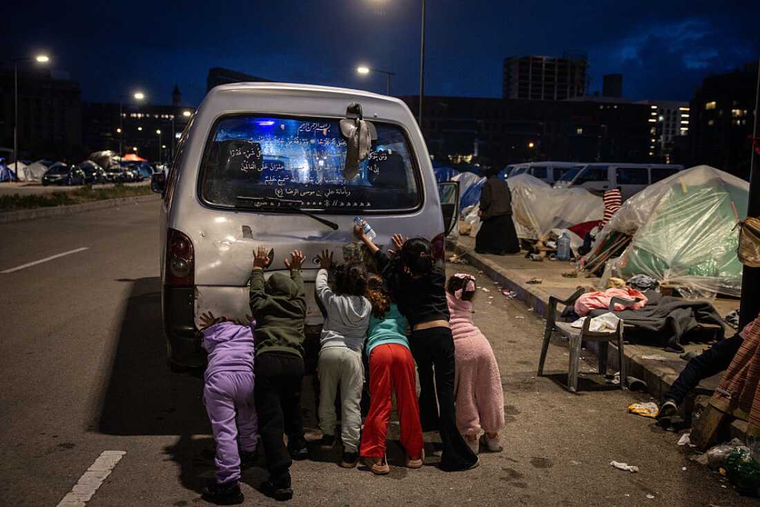 Niños desplazados ayudan a arrancar la camioneta de las familias en un campamento de desplazados temporales cerca del puerto del Líbano el 27 de marzo de 2026 en Beirut, Líbano.