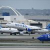 Un avión Boeing 737 MAX 9 de United Airlines pasa junto a un Boeing 737 de Southwest Airlines mientras despega del Aeropuerto Internacional de Los Ángeles (LAX).