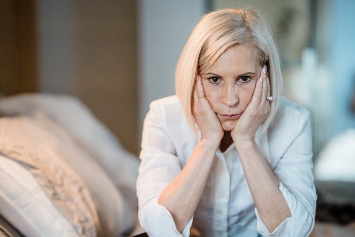 La mujer se enfrenta a un dilema mientras su madre controla la disposición para dormir con su futura esposa, luciendo preocupada y contemplativa en el interior.