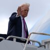 El presidente Donald Trump saluda mientras aborda el Air Force One, el domingo 29 de marzo de 2026, en el Aeropuerto Internacional de Palm Beach en West Palm Beach, Florida.